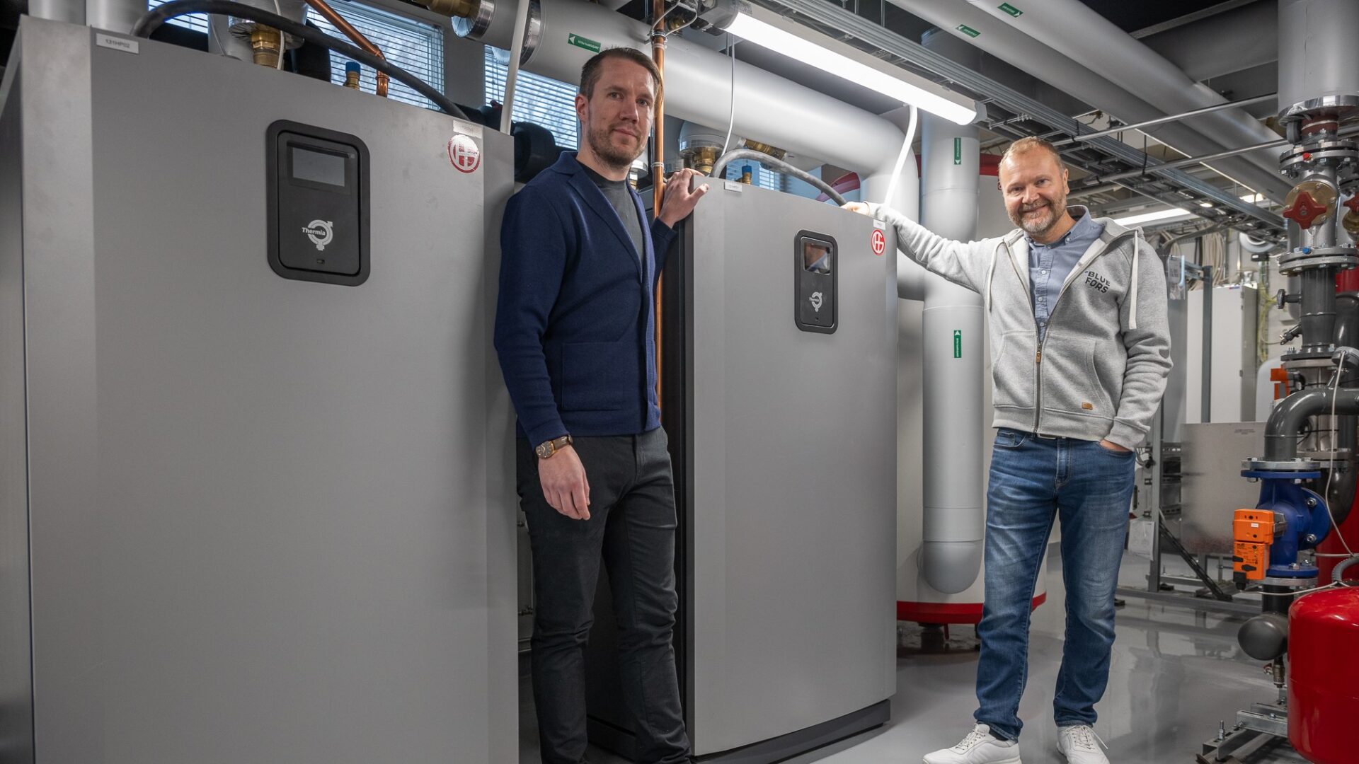 Elmo Tapola, Facility Coordinator, and Timo Palmu, Facility Director, with Bluefors Helsinki's heat recovery system.