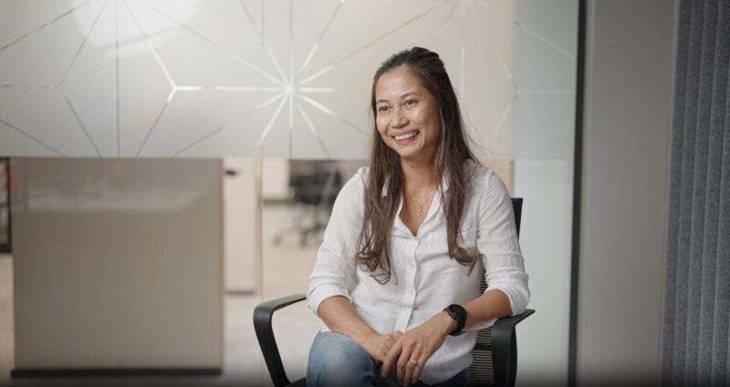 Woman sitting in a conference room smiling
