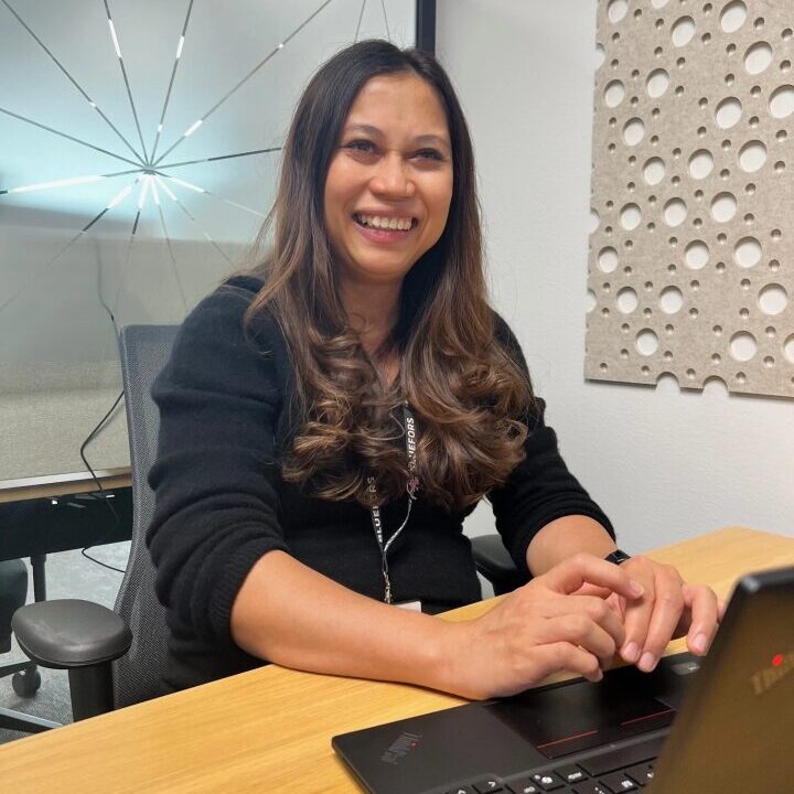 Woman working on a laptop smiling